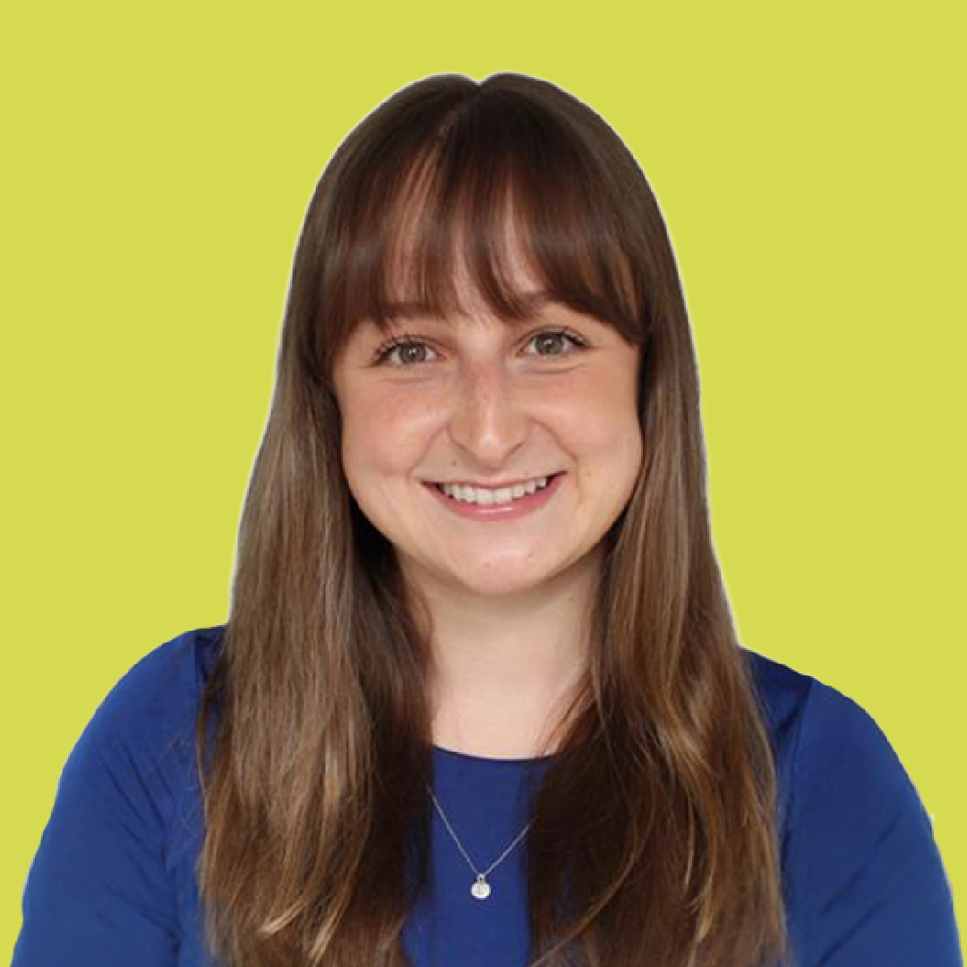 Portrait of a smiling woman with long brown hair, wearing a navy blue shirt against a bright lime-green square background.